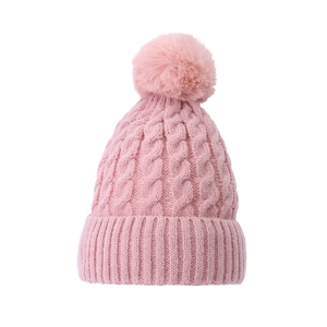 Pink chunky knit beanie hat with faux fur pom pom on top for women on white background