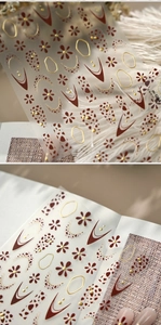 Macro detail of M-1284 nail stickers featuring red flowers and gold metallic lines