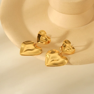 Detailed macro view of 18K gold plated heart earrings with liquid metal texture finish