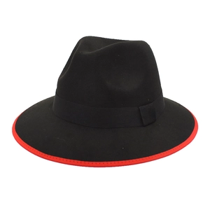 Close-up of black fedora wool hat featuring a striking red brim edge and ribbon band