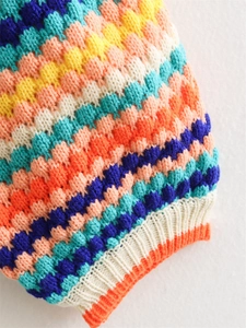Detail of multi-color popcorn stitch crochet cardigan showing textured stripes and ribbed cuffs