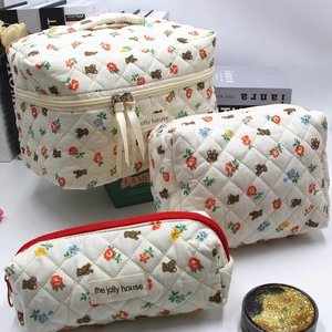 Detailed set of three quilted makeup bags with bear and floral prints in various sizes