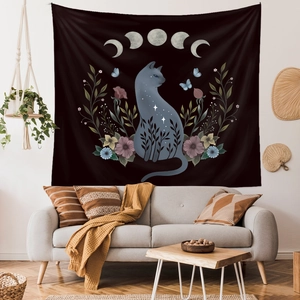 Detail of bohemian black tapestry with celestial cat and moon phases on white wall