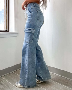 Detail view of light blue wide-leg cargo jeans with side pockets and waist drawstring