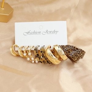 Detail of 5-piece earring set featuring gold hoops, faux pearls and leopard resin patterns