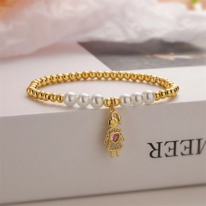Detail of beaded bracelet with gold charms, white pearls and pink heart girl pendant