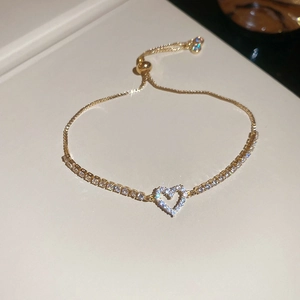 Macro shot of gold heart bracelet with sparkling zircons and adjustable pull closure
