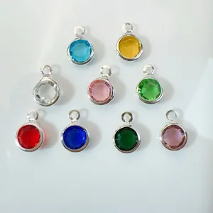 Set of nine round colored glass charms with silver metal borders for DIY jewelry making