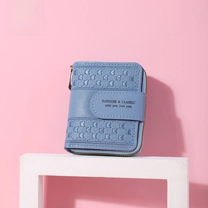 Close-up of light blue short wallet with heart embroidery and lychee leather texture