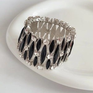 Dettaglio macro di un bracciale elastico vintage argento con pietre marquise nere e strass
