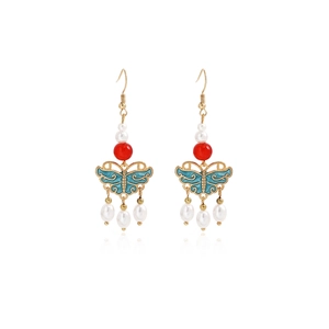 Detail view of butterfly tassel earrings with blue enamel, red beads, and white pearls