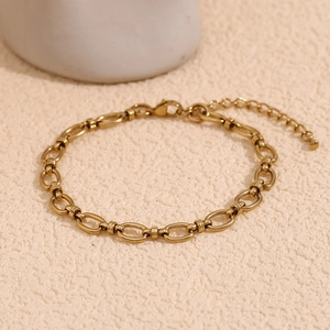 Detail of 14K gold plated stainless steel chain anklet with lobster clasp on texture