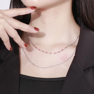 Detail of silver layered necklace with red resin beads on fine O-chain links
