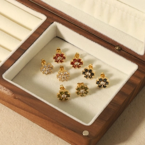 Floral cubic zirconia stud earrings in four colors on a premium jewelry display