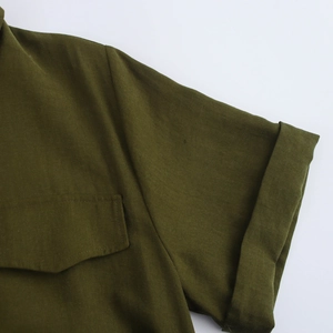Detail of short sleeves with cuffs and chest pocket on green cotton midi dress