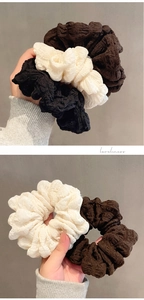 Detail of high-elasticity bubble crepe fabric scrunchies in cream and coffee colors