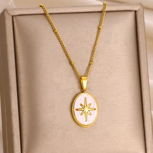 Detail of gold starburst pendant with pearl inlay inside a luxury jewelry box
