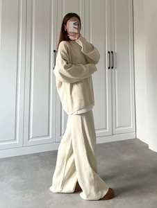 Detail of cream loose knit sweater and high-waist straight pants outfit for women