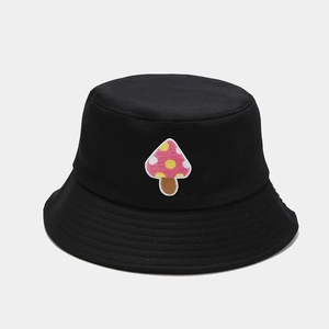 Close-up of pink mushroom embroidery detail on black cotton bucket hat for style