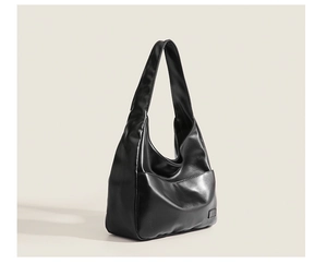 Side view of black large tote bag showing textured PU leather and structured design