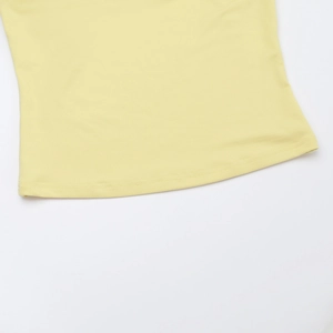 Dettaglio dell'orlo del top in pizzo giallo con cuciture a doppio ago e maglia fine