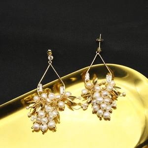 Détail macro de boucles d'oreilles perles naturelles sur plateau doré métallique