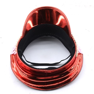 Détail du chapeau rouge avec fleurs pailletées roses, clous dorés et doublure filet