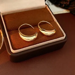 Polished 14k gold plated oval hoop earrings displayed in a brown velvet jewelry box
