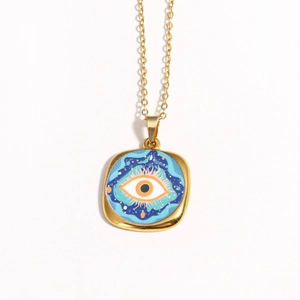 Detailed view of vintage gold evil eye pendant with blue and orange enamel drip oil art