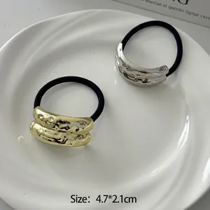 Minimalist elastic hair tie with geometric textured gold and silver metal charms