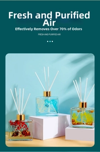 Three square glass diffusers with colorful dried flowers and golden caps for home fragrance