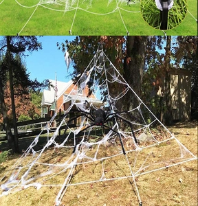 Outdoor Halloween decor featuring large white spider web and black spider with red eyes