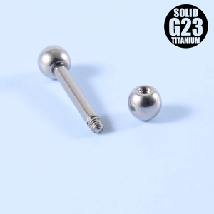 Macro shot of G23 titanium barbell piercing with external thread and polished ball ends