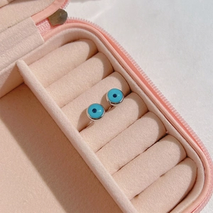 Blue Evil Eye stud earrings presented in a pink velvet jewelry box with soft lighting