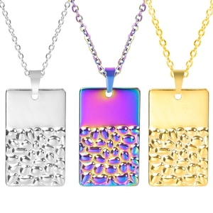 Vue détaillée de pendentifs rectangulaires en argent, or et acier arc-en-ciel avec fini martelé
