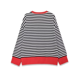 Rear view of striped knit sweater featuring black and white bands and red ribbed cuffs