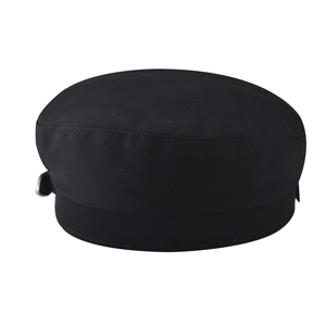 Detail view of the black cotton flat top cap with side circular metal button decoration