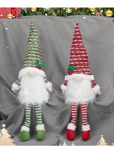 Detail of plush gnome Christmas decorations in red and green festive knitwear