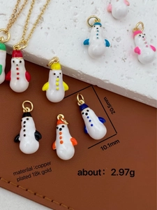 Macro shot of 18k gold plated snowman charms with colorful enamel for Christmas jewelry