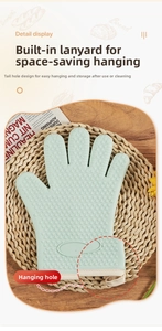 Detail of light green silicone oven mitt showing non-slip heart texture and hanging loop
