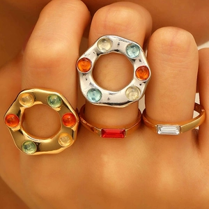 Macro shot of colorful bohemian gemstone bands and minimalist emerald cut rings set
