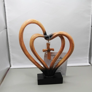 Detail of resin double heart desktop ornament with hanging cross and wood grain texture