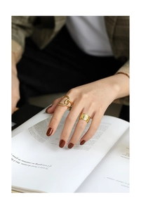 Detail of vintage gold coin ring and interlaced double ring worn on fingers