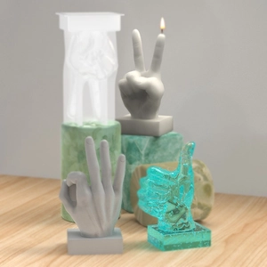 Detailed view of creative hand gesture candles on wooden desk and stone plinths