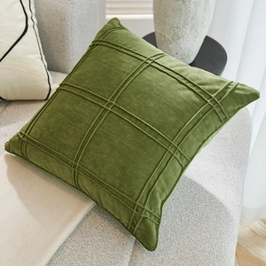 Nordic green corduroy throw pillow with square texture on a beige sofa in living room