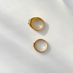 Top view of two gold couple rings with gear texture and one carat diamond stones