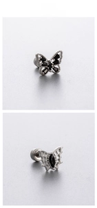 Detailed view of butterfly cartilage studs featuring black stones and spiderweb wing patterns