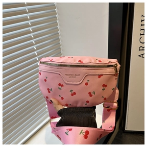 Close-up of pink crossbody bag with red cherry prints and adjustable shoulder strap