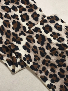 Gros plan sur le tissu imprimé léopard montrant la texture douce et les détails du motif