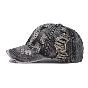 Detail of distressed denim baseball cap featuring colorful orange and green ripped threads